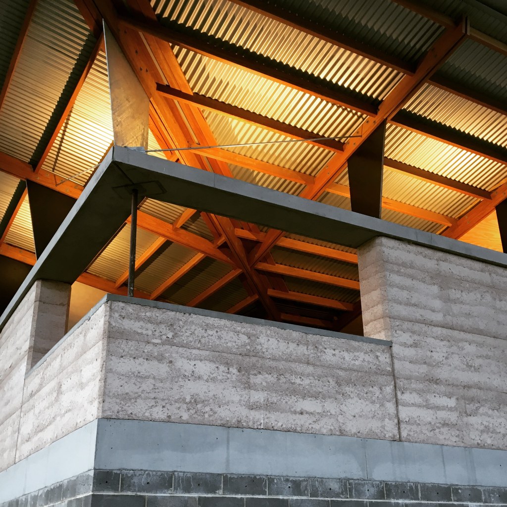 "Sunlit living room with polished concrete floors and expansive glass at Sacred Mountain House, Mulbring."